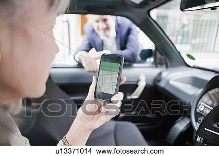 Woman getting directions on cell phone View Large Photo Image Picture - Woman getting directions on cell phone. Fotosearch