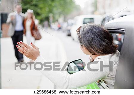 Woman hailing couple from car View Large Photo Image Stock Photo - Woman hailing couple from car. Fotosearch