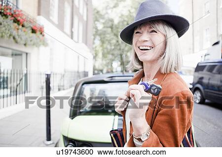 Woman holding car keys on city street View Large Photo Image Stock Image - Woman holding car keys on city street. Fotosearch