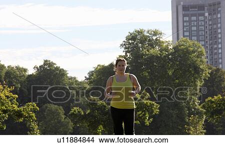 Picture - Woman jogging in urban park. Fotosearch