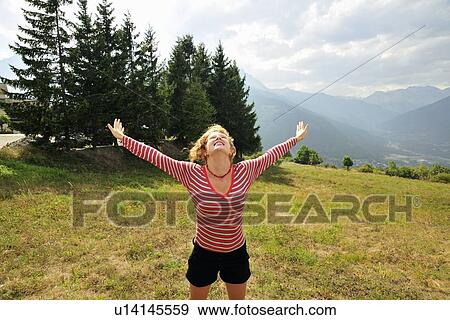 Stock Photo - Woman jumping for joy on hillside. Fotosearch
