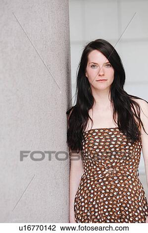 Stock Image - Woman leaning against wall. Fotosearch