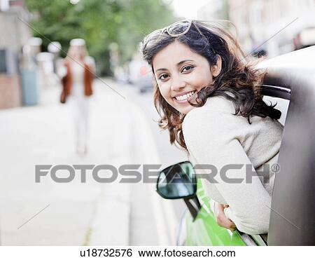 Woman leaning out of car window View Large Photo Image Stock Photograph - Woman leaning out of car window. Fotosearch