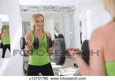 Woman lifting weights in gym View Large Photo Image Stock Photography - Woman lifting weights in gym. Fotosearch