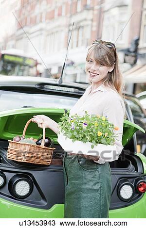 Stock Image - Woman loading produce into car. Fotosearch