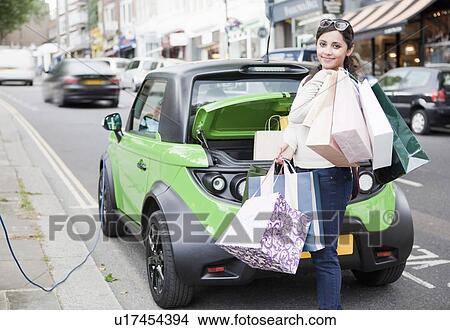 Picture - Woman loading shopping bags in car. Fotosearch