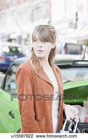 Stock Image - Woman loading shopping bags in car. Fotosearch