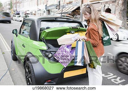 Woman loading shopping bags in car View Large Photo Image Stock Photo - Woman loading shopping bags in car. Fotosearch