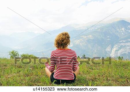 Woman meditating on rural hilltop View Large Photo Image Stock Image - Woman meditating on rural hilltop. Fotosearch