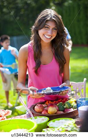 Woman serving herself food outdoors View Large Photo Image Stock Image - Woman serving herself food outdoors. Fotosearch