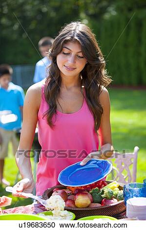 Woman serving herself food outdoors View Large Photo Image Stock Image - Woman serving herself food outdoors. Fotosearch