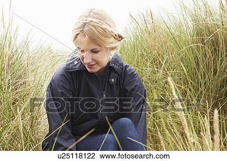 Woman sitting in tall grass View Large Photo Image Stock Image - Woman sitting in tall grass. Fotosearch