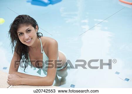 Stock Image - Woman standing in swimming pool. Fotosearch