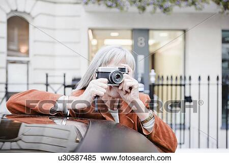 Woman taking picture on city street View Large Photo Image Stock Photography - Woman taking picture on city street. Fotosearch