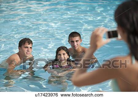 Woman taking pictures of family in pool View Large Photo Image Stock Photograph - Woman taking pictures of family in pool. Fotosearch