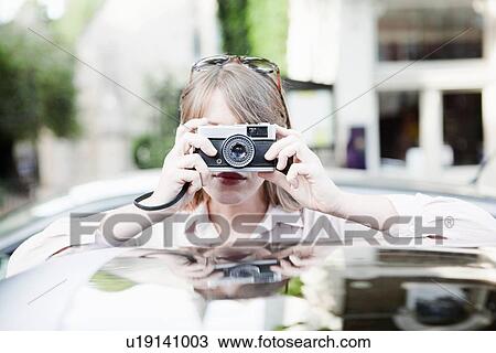 Woman taking pictures on city street View Large Photo Image Stock Image - Woman taking pictures on city street. Fotosearch