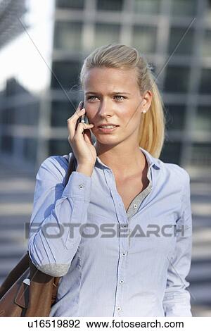 Stock Image - Woman talking on cell phone on street. Fotosearch