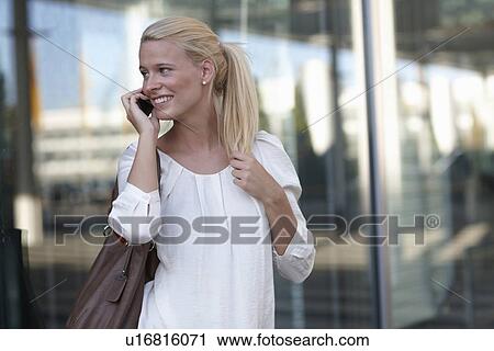 Woman talking on cell phone on street View Large Photo Image Stock Image - Woman talking on cell phone on street. Fotosearch