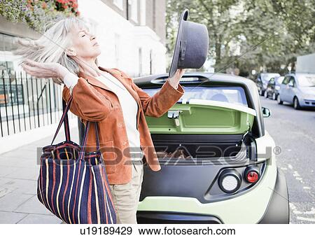 Stock Photo - Woman tossing hair on city street. Fotosearch