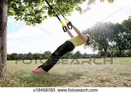 Woman using exercise straps outdoors View Large Photo Image Stock Image - Woman using exercise straps outdoors. Fotosearch