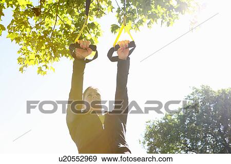 Woman using exercise straps outdoors View Large Photo Image Stock Photo - Woman using exercise straps outdoors. Fotosearch