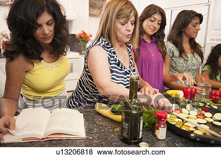 Women cooking together in kitchen View Large Photo Image Stock Photo - Women cooking together in kitchen. Fotosearch