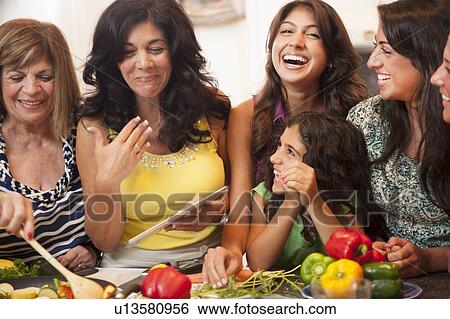 Women cooking together in kitchen View Large Photo Image Stock Photograph - Women cooking together in kitchen. Fotosearch