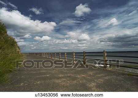 Wooden posts on paved coastal road View Large Photo Image Stock Photograph - Wooden posts on paved coastal road. Fotosearch