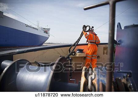 Worker on tug boat holding rope View Large Photo Image Stock Image - Worker on tug boat holding rope. Fotosearch