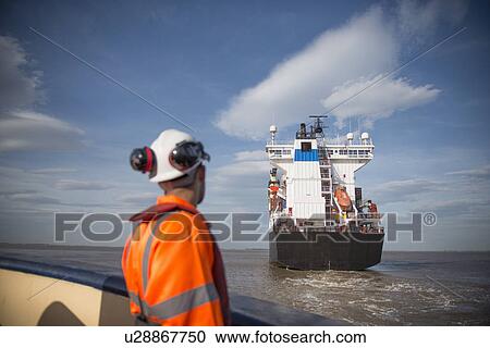 Worker on tug boat overlooking ship View Large Photo Image Stock Image - Worker on tug boat overlooking ship. Fotosearch