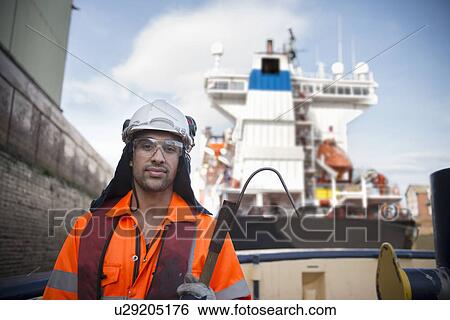 Stock Photograph - Worker standing on tug boat. Fotosearch
