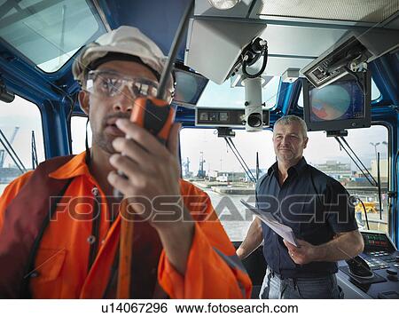 Stock Photograph - Worker talking in tugboat wheelhouse. Fotosearch