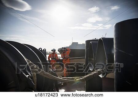 Workers on tug boat overlooking ship View Large Photo Image Stock Image - Workers on tug boat overlooking ship. Fotosearch