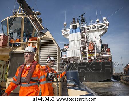 Workers on tug boat pulling in rope View Large Photo Image Stock Image - Workers on tug boat pulling in rope. Fotosearch