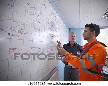 Workers planning operations on board View Large Photo Image Stock Photography - Workers planning operations on board. Fotosearch