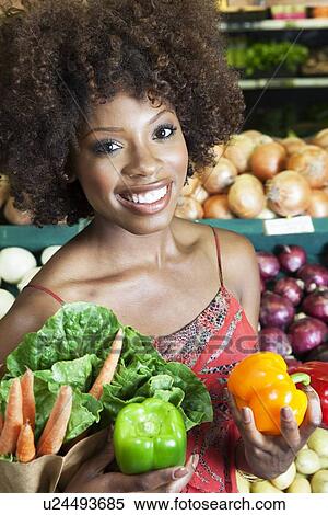 African American woman holding bell peppers and vegetables at supermarket View Large Photo Image Stock Photography - African American woman holding bell peppers and vegetables at supermarket. Fotosearch