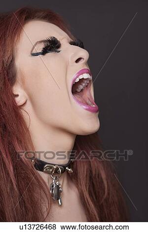 Close-up of young funky woman screaming against black background View Large Photo Image Stock Photo - Close-up of young funky woman screaming against black background. Fotosearch