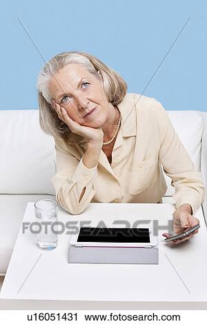 Contemplative woman using cell phone and tablet PC at table View Large Photo Image Stock Image - Contemplative woman using cell phone and tablet PC at table. Fotosearch