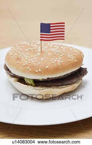 Grilled hamburger in plate with American flag on wooden surface View Large Photo Image Picture - Grilled hamburger in plate with American flag on wooden surface. Fotosearch