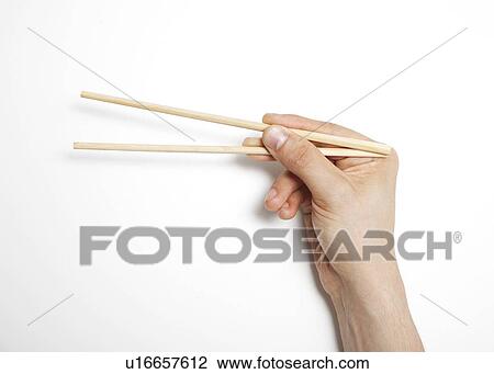 Man's hand gripping chopsticks over white background View Large Photo Image Stock Image - Man's hand gripping chopsticks over white background. Fotosearch