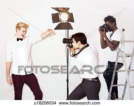 Picture - Paparazzi taking photographs of male actor over white background. Fotosearch