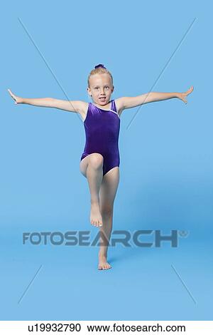 Portrait of a young female gymnast performing over blue background View Large Photo Image Stock Image - Portrait of a young female gymnast performing over blue background. Fotosearch