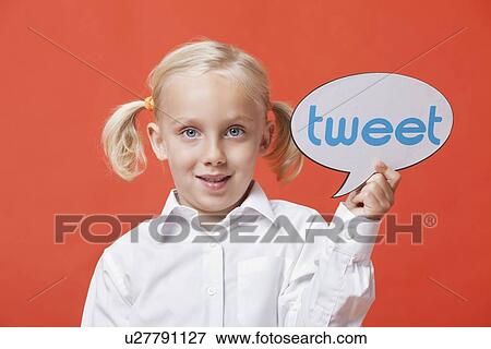 Stock Photo - Portrait of a young girl holding tweet bubble against orange background. Fotosearch