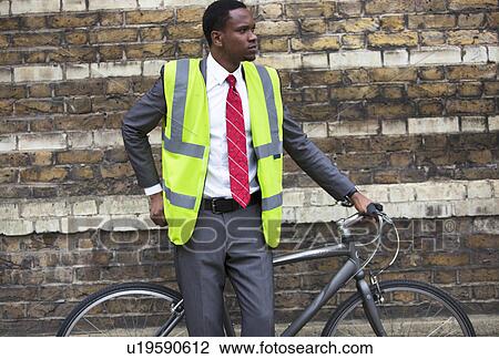 Portrait of African American businessman in safety vest with Bicycle View Large Photo Image Stock Image - Portrait of African American businessman in safety vest with Bicycle. Fotosearch