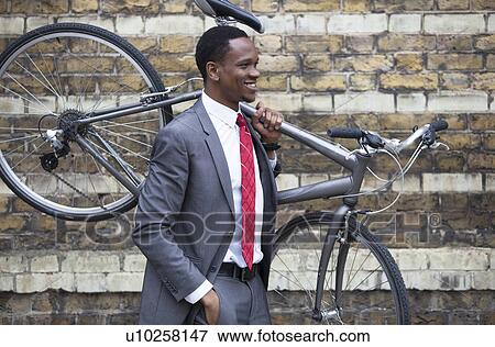 Portrait of African American businessman carrying Bicycle View Large Photo Image Stock Photo - Portrait of African American businessman carrying Bicycle. Fotosearch