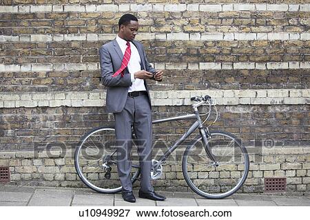 Stock Photo - Portrait of African American businessman with Bicycle. Fotosearch