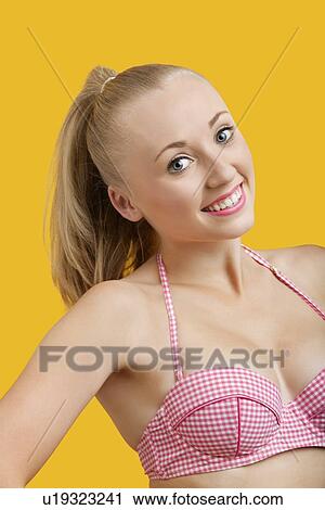 Portrait of beautiful young woman against yellow background View Large Photo Image Stock Image - Portrait of beautiful young woman against yellow background. Fotosearch