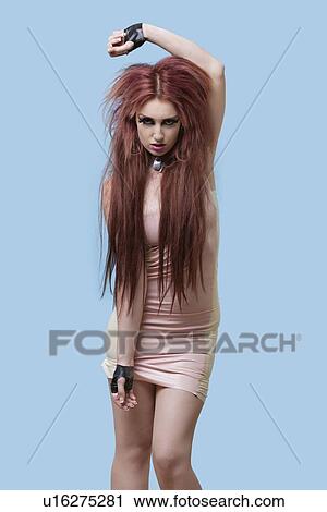 Portrait of funky young woman in mini dress standing over blue background View Large Photo Image Stock Image - Portrait of funky young woman in mini dress standing over blue background. Fotosearch