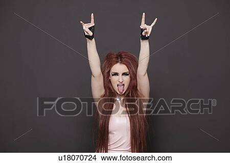 Portrait of funky young woman sticking out tongue and making rebellious gestures over black background View Large Photo Image Picture - Portrait of funky young woman sticking out tongue and making rebellious gestures over black background. Fotosearch