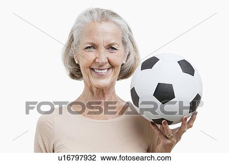 Portrait of senior woman holding soccer ball against white background View Large Photo Image Stock Image - Portrait of senior woman holding soccer ball against white background. Fotosearch